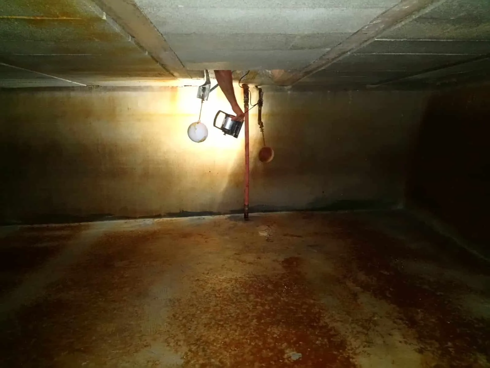 Interior of a cistern with rust and sediment built up on the walls
