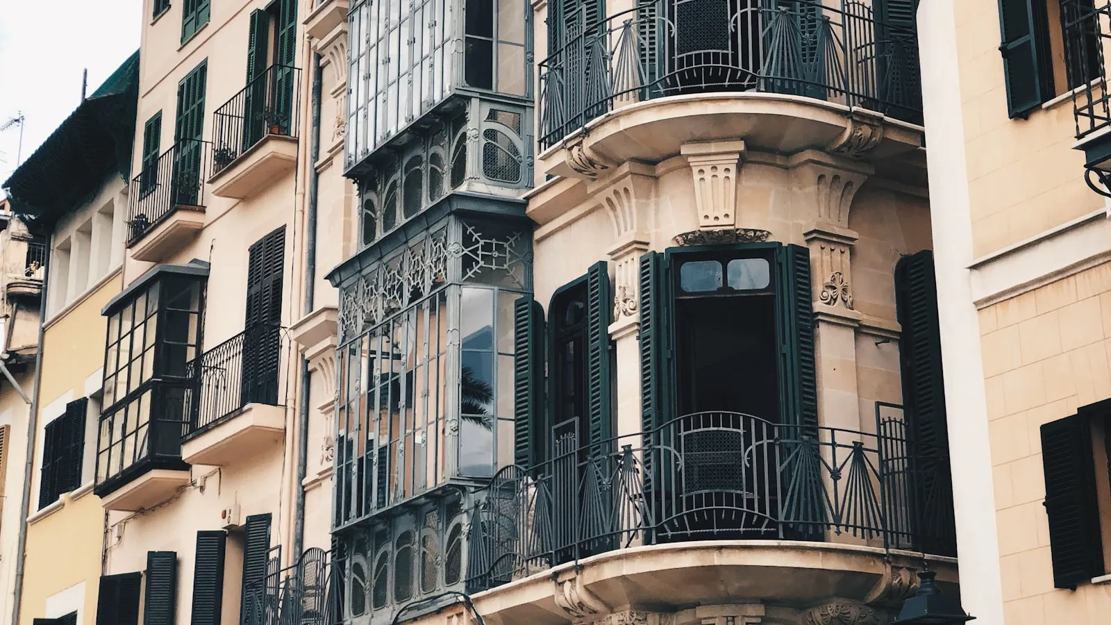 Facade of an old building in Palma with balconies and green shutters