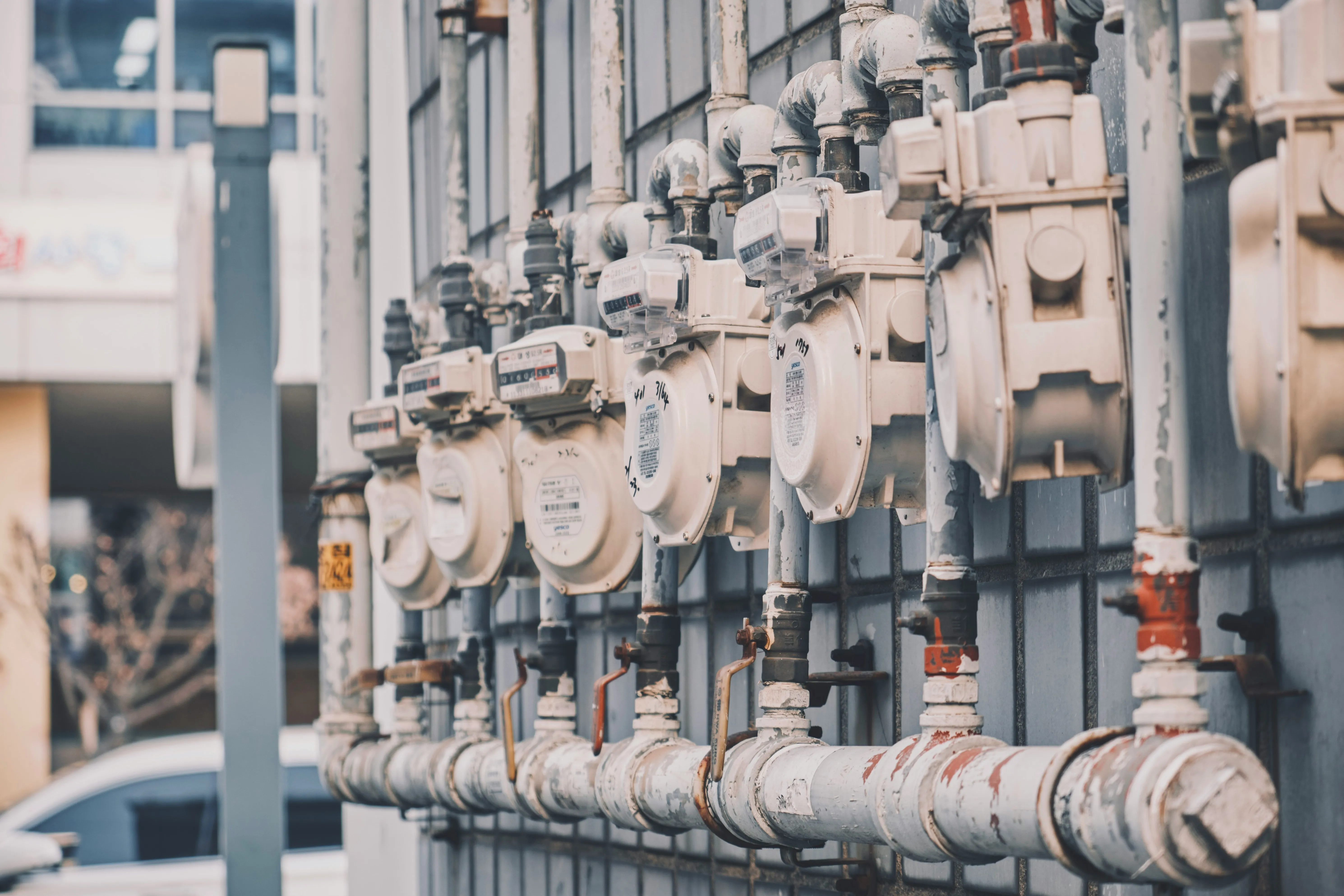 Row of pipes and meters on an old building's façade