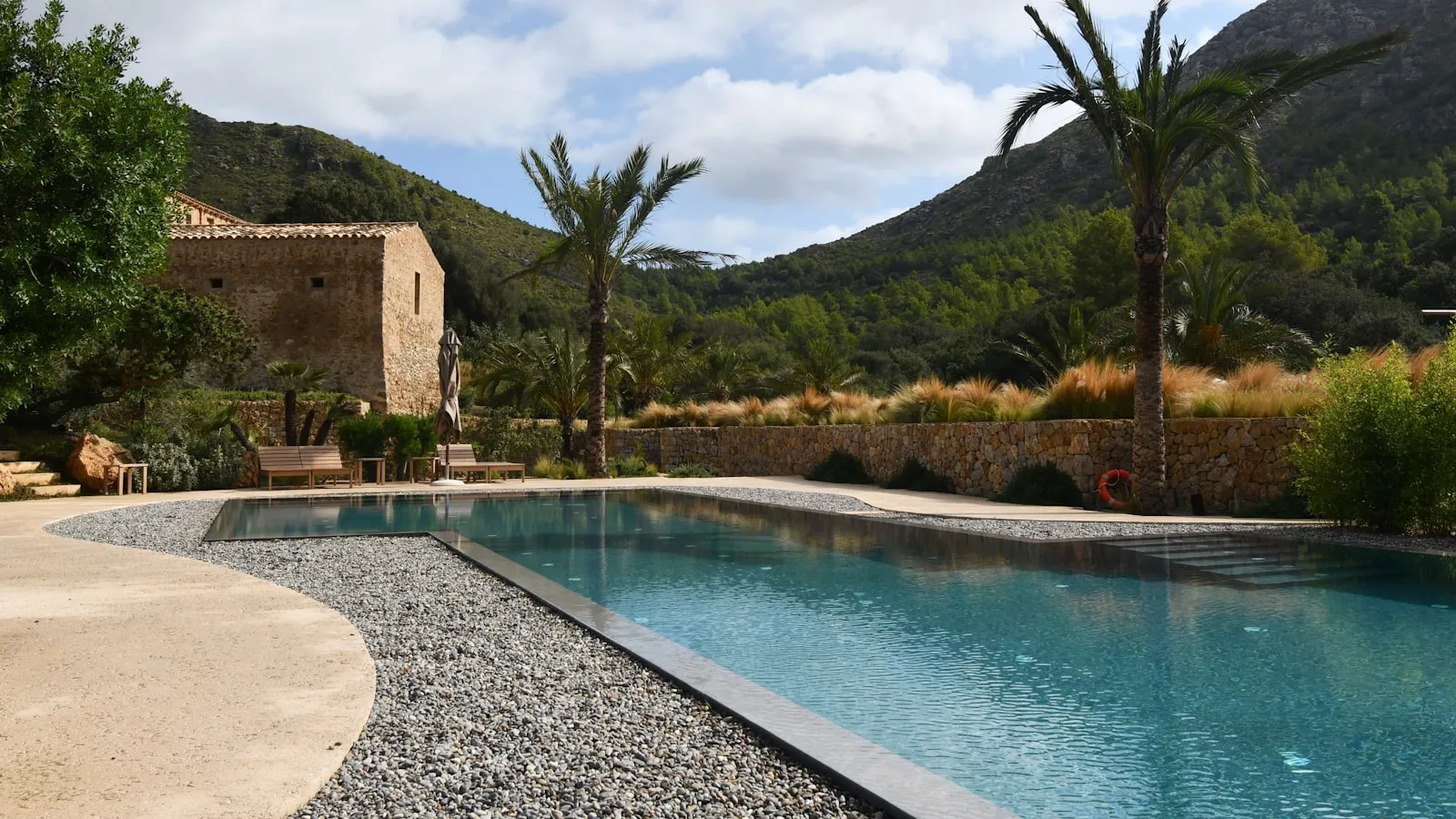 Mallorcan stone villa with a pool and palm trees at the foot of the mountains